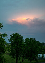 landscape with a colorful sunset over the roof, view through the window