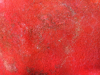 A landscape shot of a red textured background with tiny little white dots