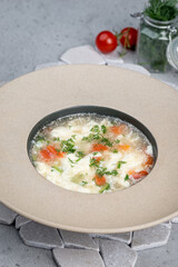 Soup with egg and fresh herbs in a deep plate
