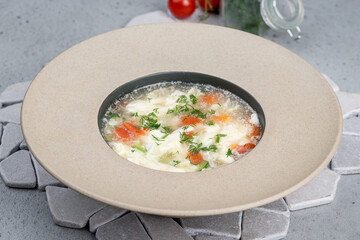 Soup with egg and fresh herbs in a deep plate