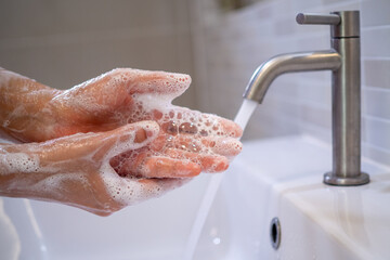 Women are washing their hands with foam soap and clean water. Wash your hands to keep them clean...