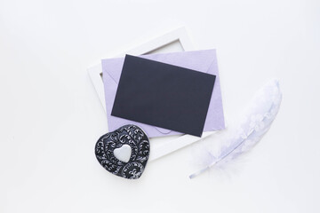 framework for invitation or congratulation. original message concept. envelope with a letter, a box in the form of a heart and a feather on a white background