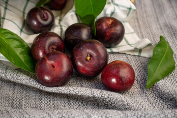 purple plums in striped cloth, placed in a wicker