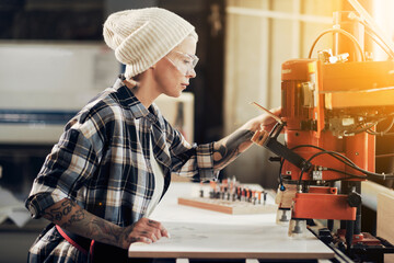 Female craftsman working at joiner machine