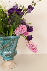 Bouquet of pink hyacinthus and purple lisianthus in a turquoise