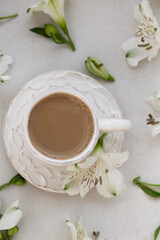 Obraz na płótnie Canvas Morning coffee with flowers over light gray tabletop.