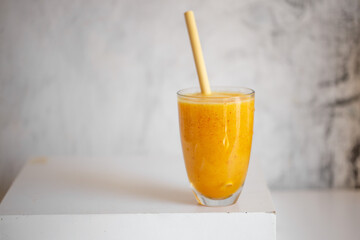 Tasty peach smoothie in glass on white table
