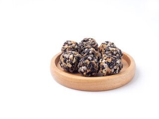 Black sesame cereal ball in wooden circle plate isolated on a white background. .