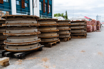 metal manhole covers from the sewer are stacked in a row on the street, road works, construction materials