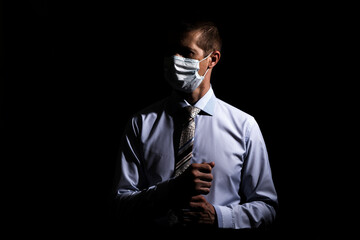 business successful man in a medical mask, slave and tie, portrait. on black