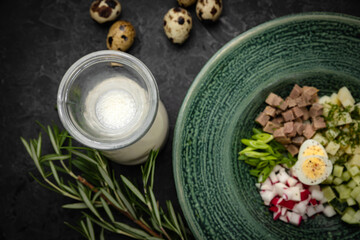 Top view of traditional Russian summer kefir or yogurt cold soup with vegetables called Okroshka....