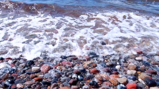The rocky coast of the Baltic Sea and waves beat against stones on the island of Fehmarn, Germany
