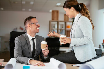 Colleagues in office. Businesswoman and businessman discussing work and drinking coffe in office	