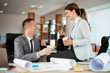 Colleagues in office. Businesswoman and businessman discussing work and drinking coffe in office	