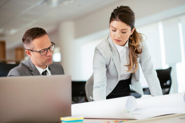 Obraz premium Colleagues in office. Businesswoman and businessman discussing work in office. 