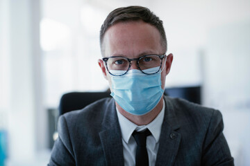 Handsome businessman with medical mask. Young man working in office.	