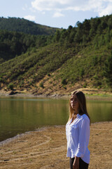 Beautiful woman with long hair on the background of nature seeing the lake. Melero Meander, Batuecas National Park