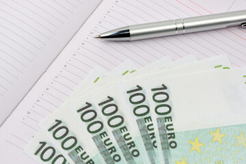 Euro close-up. Macro of money. Cash banknotes are stacked. Ballpoint pen.