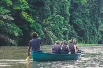 Fototapeta na wymiar Tourists with rowboat exploring the Rio Tortuguero national park. Ecotourism concept. Costa Rica.