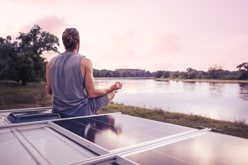 Man meditating on the roof of a camper van