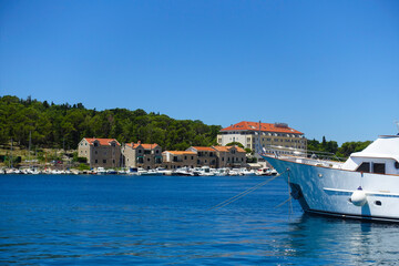 Makarska Chorwacja widok na jacht i w tle zabudowania starego miasta. Lazurowe morze Adriatyckie i błękitne niebo - obrazy, fototapety, plakaty