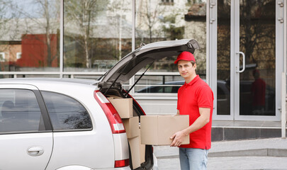 Delivery by car to door. Courier takes big box from trunk