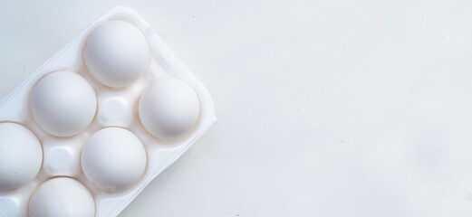 Fototapeta na wymiar Several eggs in an open package on a white background