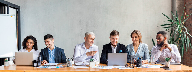 Happy Coworkers Working Together Discussing Project Sitting In Office, Panorama