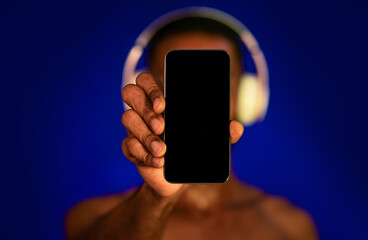 Shirtless Sporty Guy Showing Smartphone Screen On Blue Background, Mockup