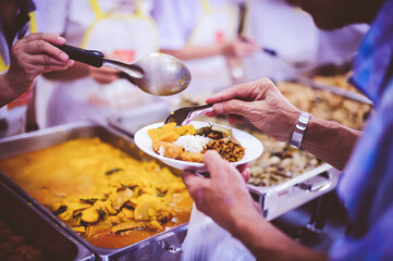 The hands of beggars receive donated food : concept of charity food for the poor