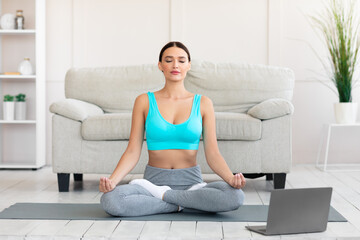 Fototapeta na wymiar Peaceful Woman Meditating During Online Yoga Class At Home