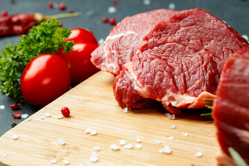 Slice of raw beef fillet on wooden board