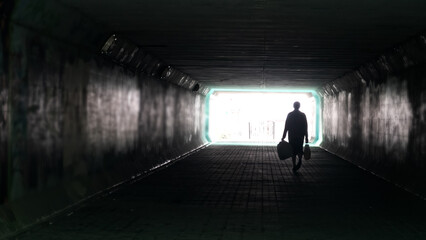 Silhouette of woman in dark underpass. Danger of loneliness and insecurity in city