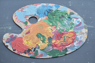Above view of artists palette with colorful paint strokes on table, art equipment concept