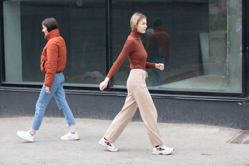 Fototapeta na wymiar Two girls walking on the city street. Young woman outdoors.