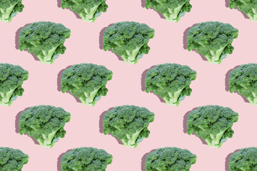 Seamless regular  creative pattern of broccoli slices on a pink background.Top view.Photo collage,hard light,shadow,pop art design. Food blog, vegetable background. Printing on fabric, wrapping paper.