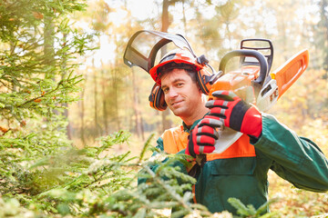 Content forest worker with chainsaw in the forest