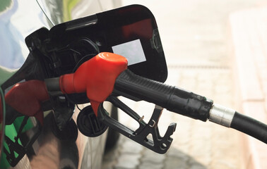 Closeup of man pumping gasoline fuel in car at gas station.
