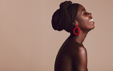 Fashionable african woman smiling on beige background