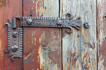 Old rusty door hinge on wooden planks, decoration detail