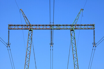 Electric wires against the blue sky. High voltage powerline tower. Electricity transmission pylon....