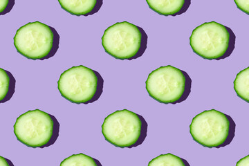 Regular seamless creative pattern of cucumber slices on a violet background.Photo collage,hard lightshadow,pop art design.Top view. Food blog, vegetable background. Printing on fabric, wrapping paper.