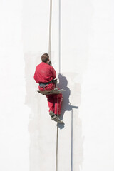 Plasterer is reparing a white wall.