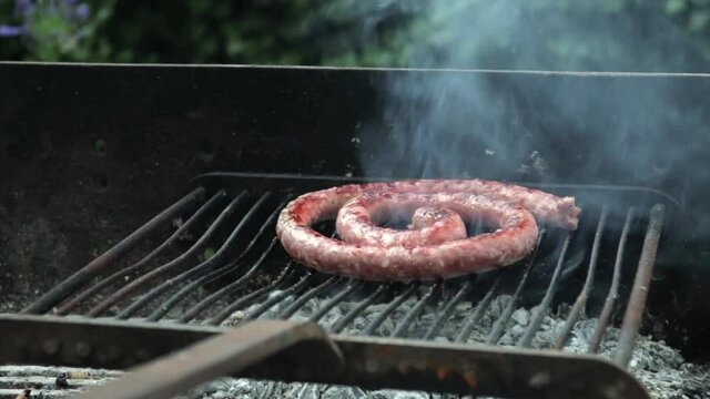 Une saucisse gille sur un barbecue.