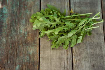 The rucola lies on old wooden boards. With copy space. Top view