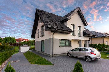 A modern single family house with a garden at sunset