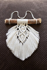 Popular openwork macrame leaf made of white cotton thread on a wooden stick - obrazy, fototapety, plakaty
