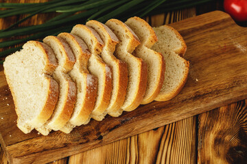 Sliced loaf of bread on wooden board