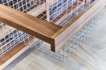 Storage organization. Metal mesh basket in wooden drawer in food storage room