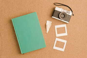 vacation, travel and summer vacation concept: light blue book, with retro photo camera, be shell in...